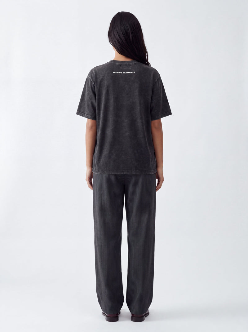 Model wearing the Elusive Stamp Tee, back view