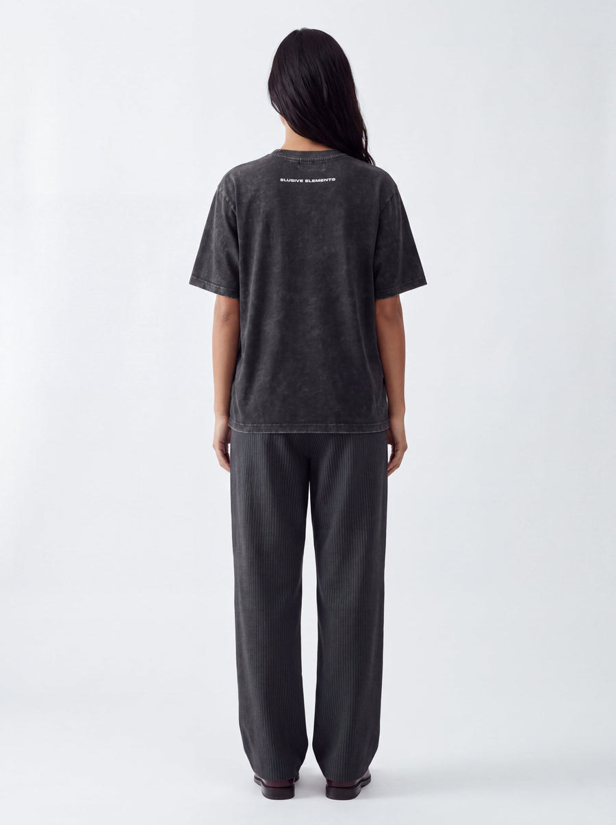Model wearing the Elusive Stamp Tee, back view