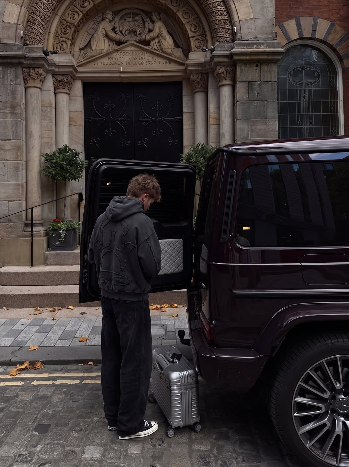 Loading a car outside an old stone church